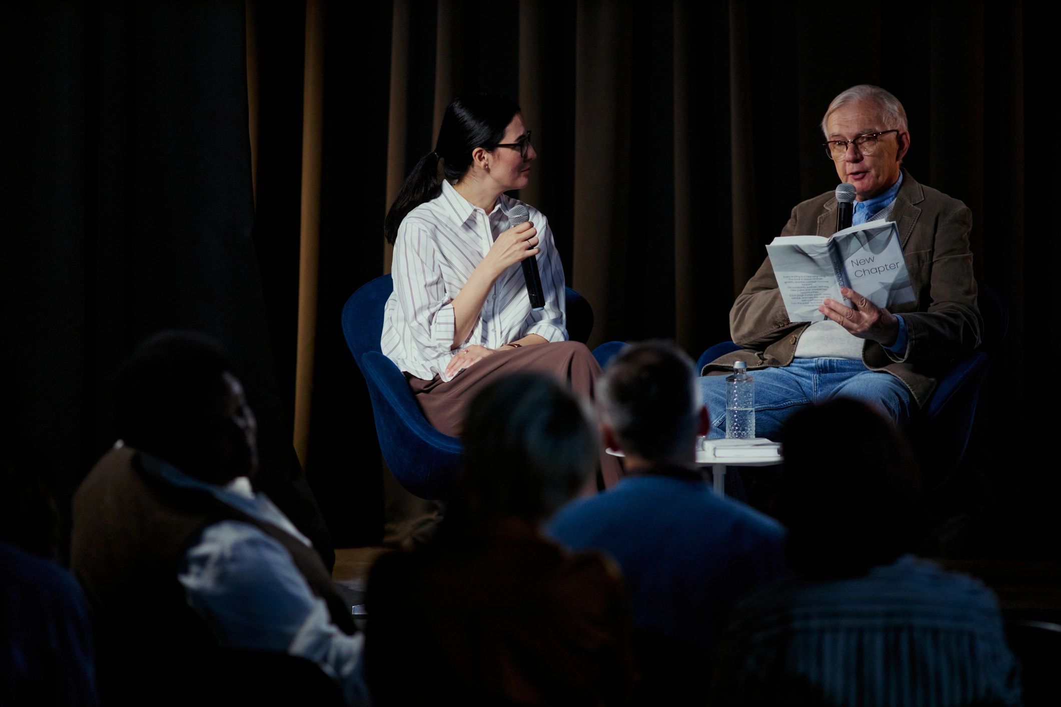 Speaker and moderator on stage during a live audience event